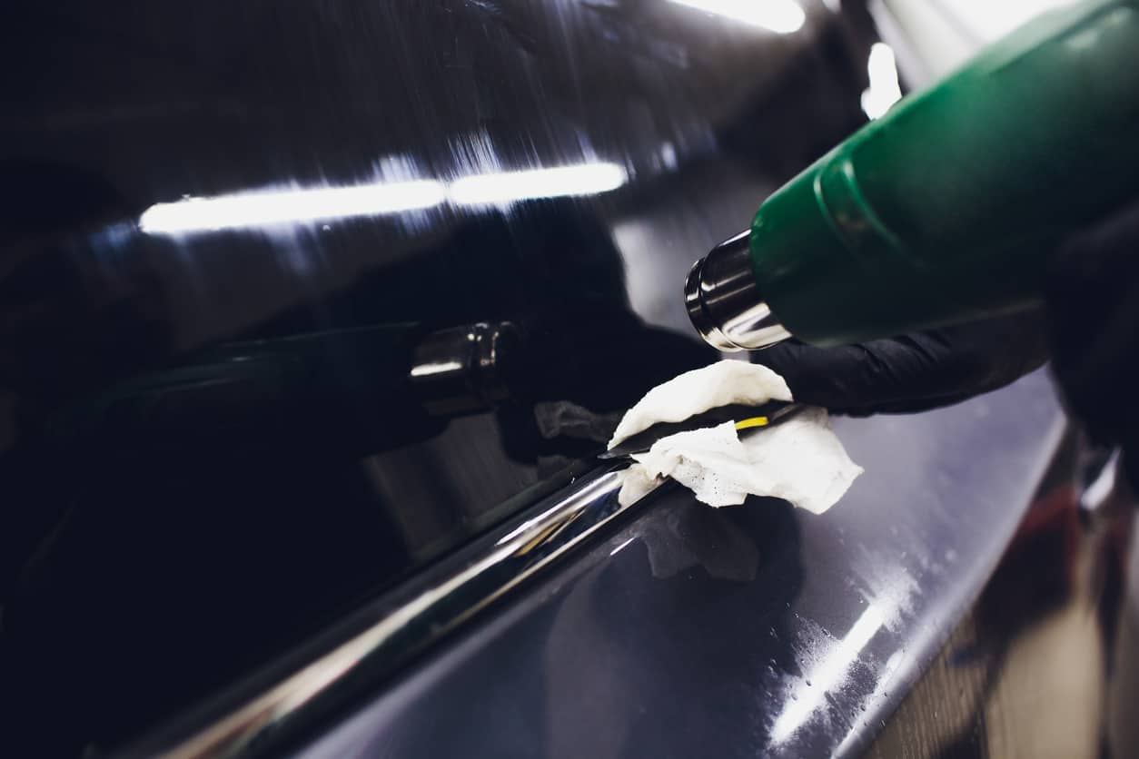 Applying tinting foil on car window in garage